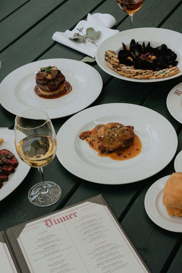 Dinner table with elegant entrees on white plates.