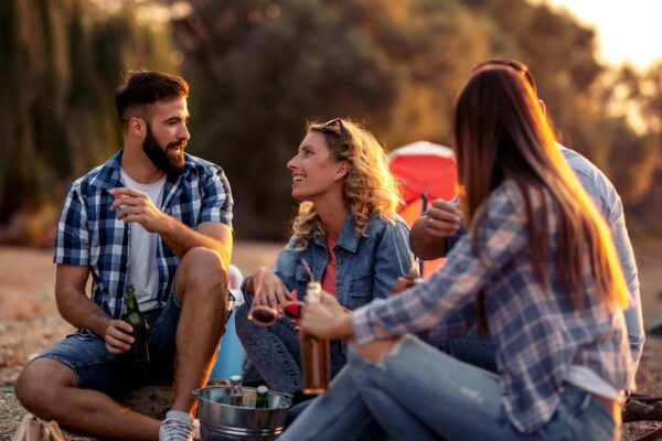 Friends camping together on beach.