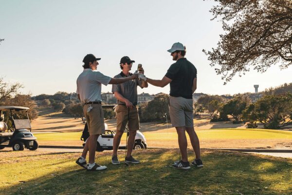 Friends playing golf together in the sunshine.