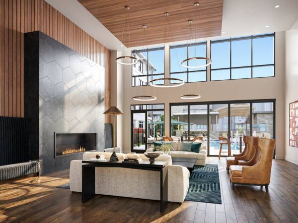 Spacious resident clubroom at Embark Apartments with soaring ceilings, expansive windows, a modern fireplace, stylish lounge seating, and warm wood finishes, creating an inviting space for residents to gather, unwind, and connect.